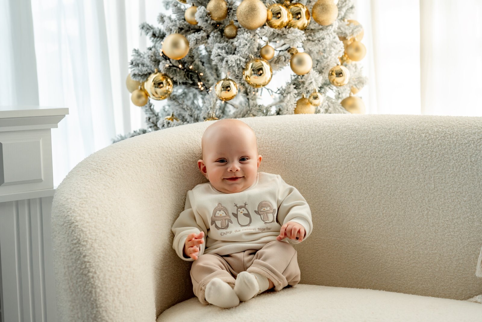 Bébé dans le décor de Noël blanc et doré du studio de Le Teil